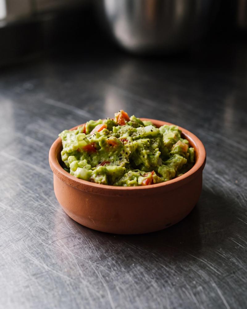 Guacamole van grof geprakte avocado met rode peper, blokjes tomaat en limoensap